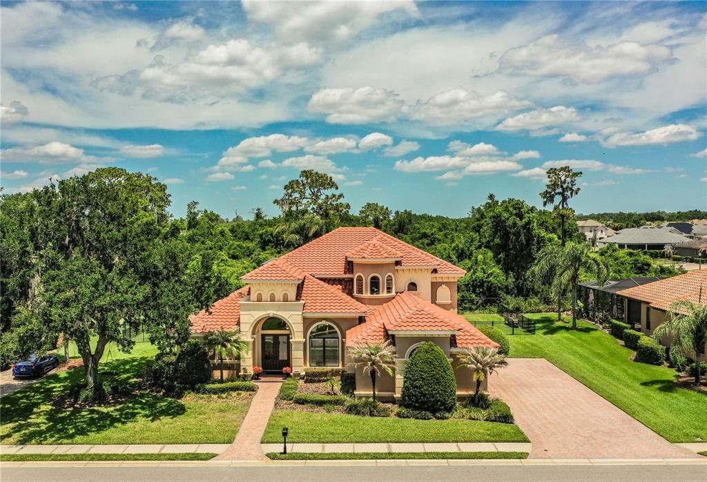 6739 Eagle Ridge Boulevard Lakeland, FL 33813 - Photo 42 of 54 a view of a white house with a big yard and large trees