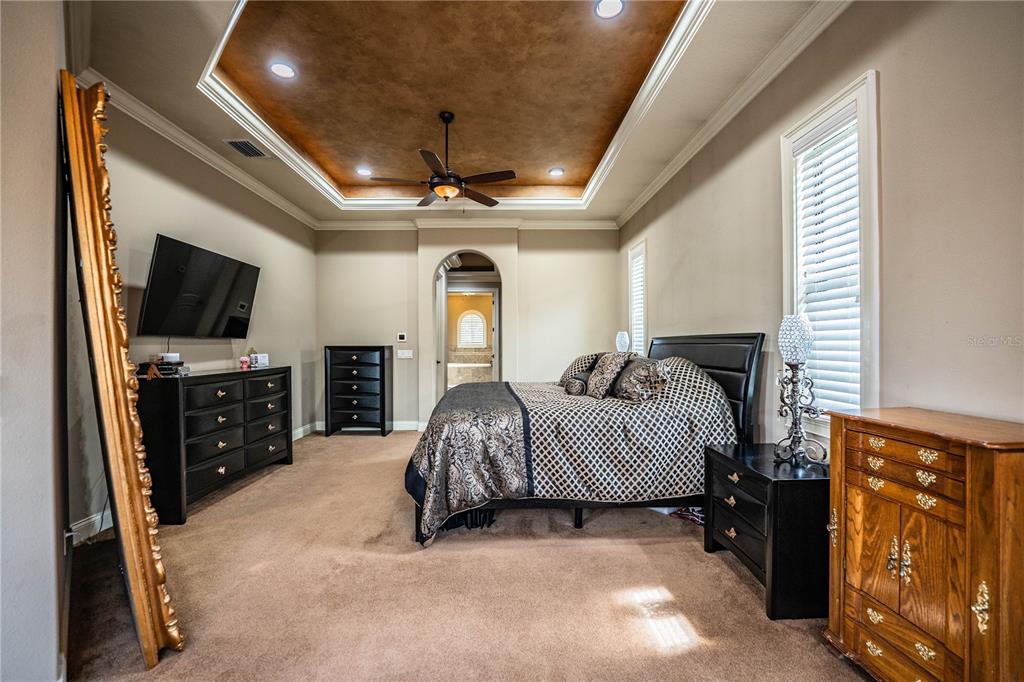 6739 Eagle Ridge Boulevard Lakeland, FL 33813 - Photo 9 of 54 a spacious bedroom with a bed and a flat tv screen on dresser