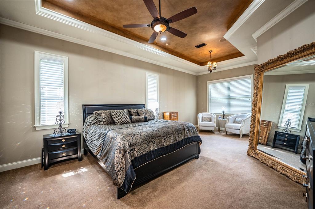 6739 Eagle Ridge Boulevard Lakeland, FL 33813 - Photo 10 of 54 a spacious bedroom with a bed couch chandelier and a window