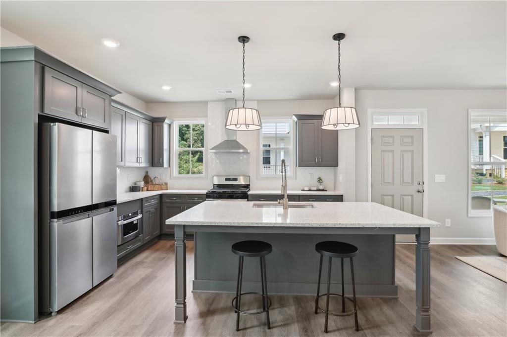 911 East Green Lane Clarkston, GA 30021 - Photo 9 of 43 a kitchen with stainless steel appliances kitchen island granite countertop a kitchen island hardwood floor and a sink