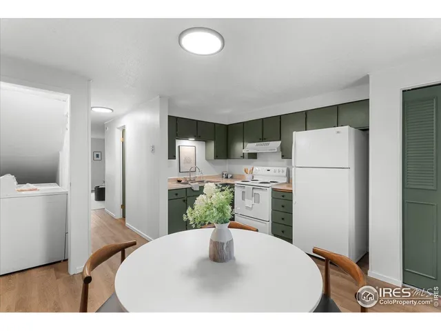 a kitchen with refrigerator and white cabinets