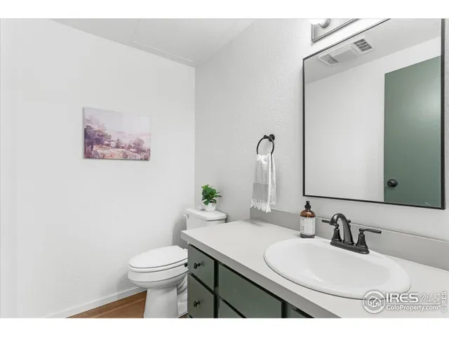 a bathroom with a granite countertop sink mirror a toilet and a sink