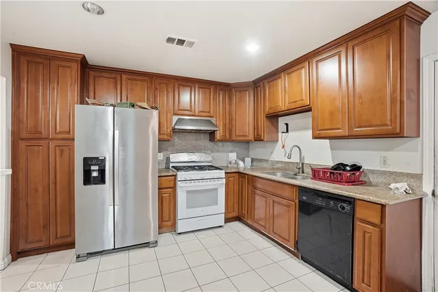 a kitchen with stainless steel appliances granite countertop a refrigerator sink and cabinets