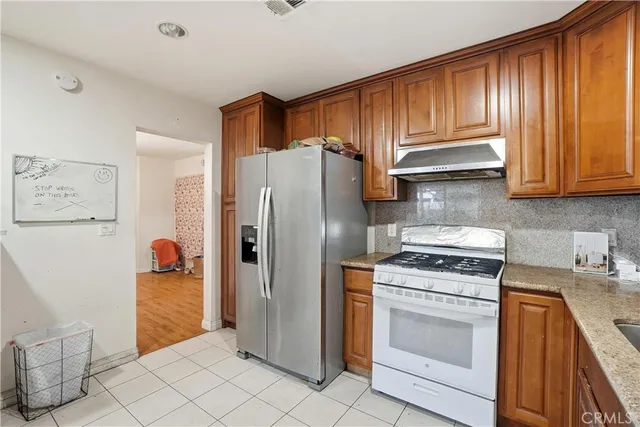 a kitchen with stainless steel appliances granite countertop a refrigerator sink and stove