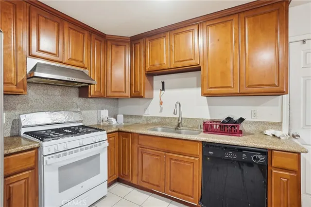 a kitchen with stainless steel appliances granite countertop a sink stove and cabinets