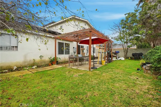 a view of a chair and table in backyard of the house