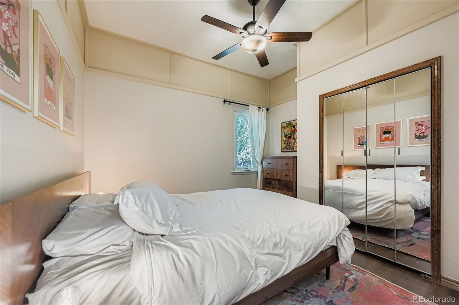 845 Martin Street Longmont, CO 80501 - Photo 7 of 18 a bedroom with a large bed and a chandelier