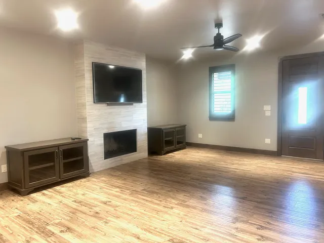 a view of a livingroom with a fireplace cabinet and a window