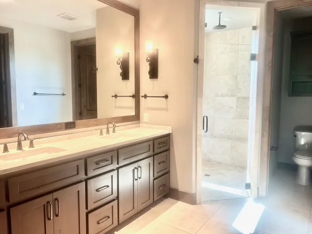 a spacious bathroom with a shower sink and mirror