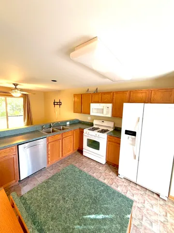 a kitchen with stainless steel appliances granite countertop a refrigerator sink and stove