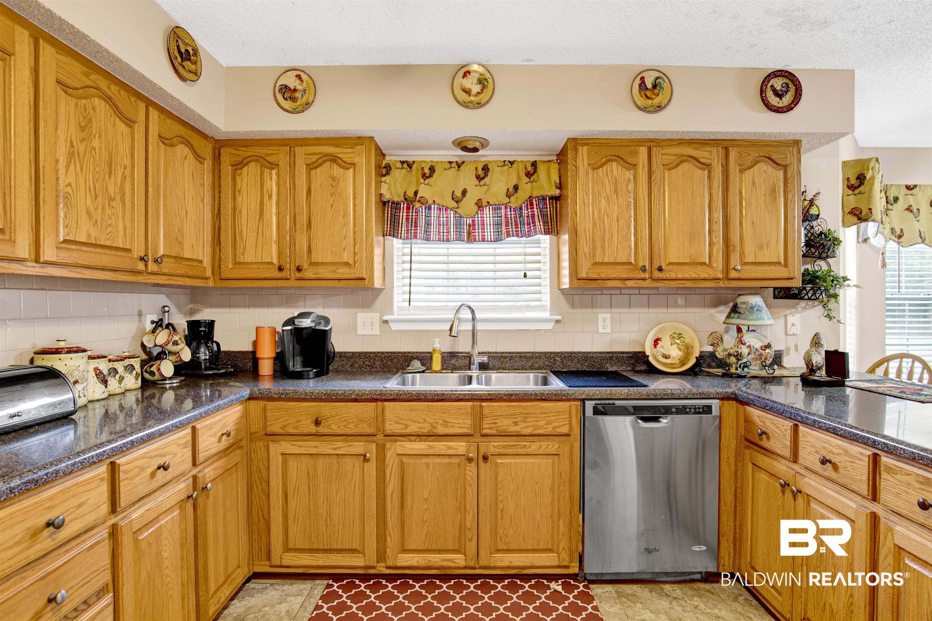 36434 Alexandria Trail Stapleton, AL 36578 - Photo 25 of 27 Kitchen with dishwasher, tasteful backsplash, brown cabinets, a textured ceiling, and dark stone countertops