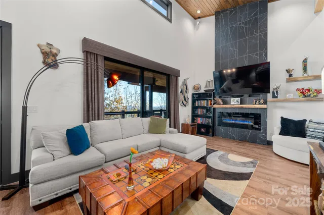 a living room with furniture a large window and a flat screen tv