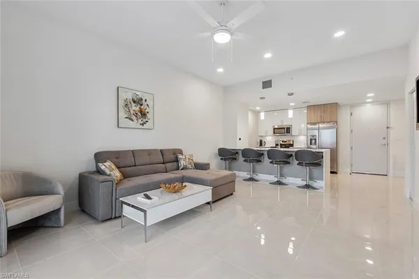 a living room with furniture and a view of kitchen