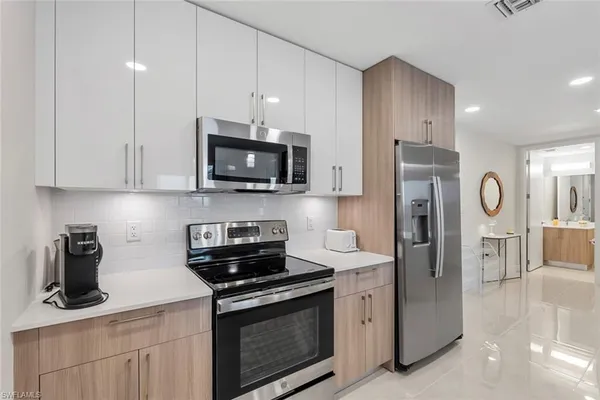 a kitchen with stainless steel appliances granite countertop a stove a sink and a white cabinets