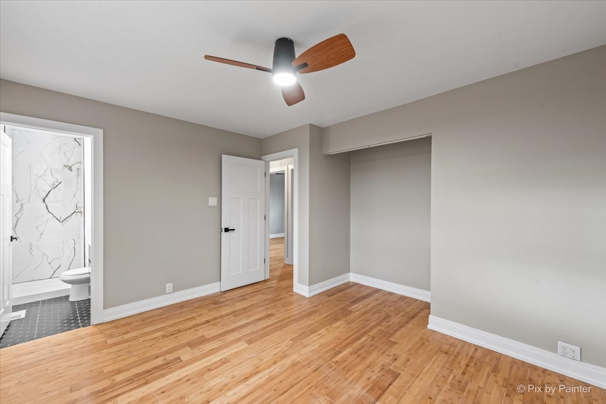 542 East Briarcliff Road Bolingbrook, IL 60440 - Photo 14 of 26 an empty room with wooden floor cabinet and windows