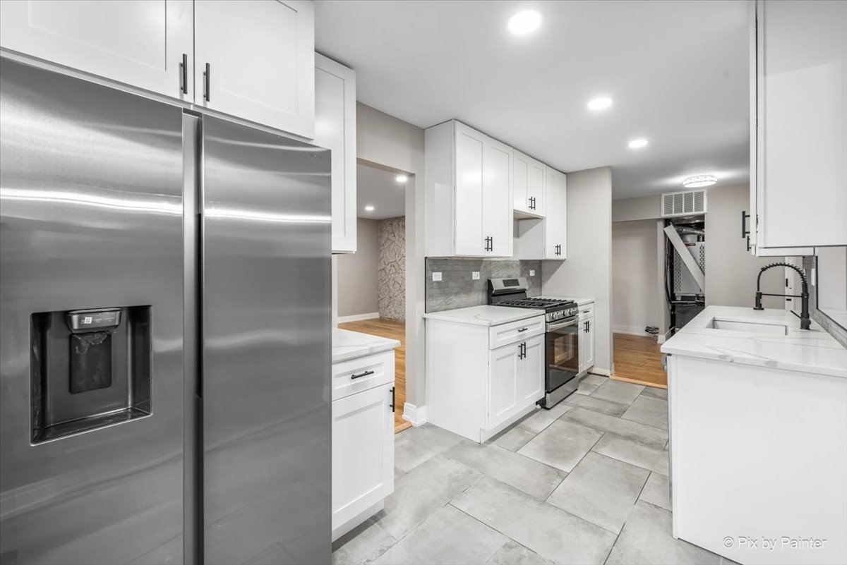 542 East Briarcliff Road Bolingbrook, IL 60440 - Photo 6 of 26 a kitchen with a refrigerator sink and cabinets