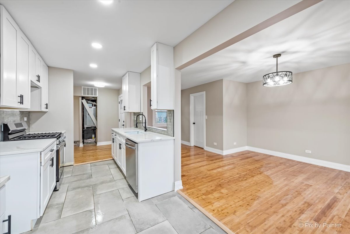 542 East Briarcliff Road Bolingbrook, IL 60440 - Photo 7 of 26 a large kitchen with kitchen island a sink stainless steel appliances and cabinets