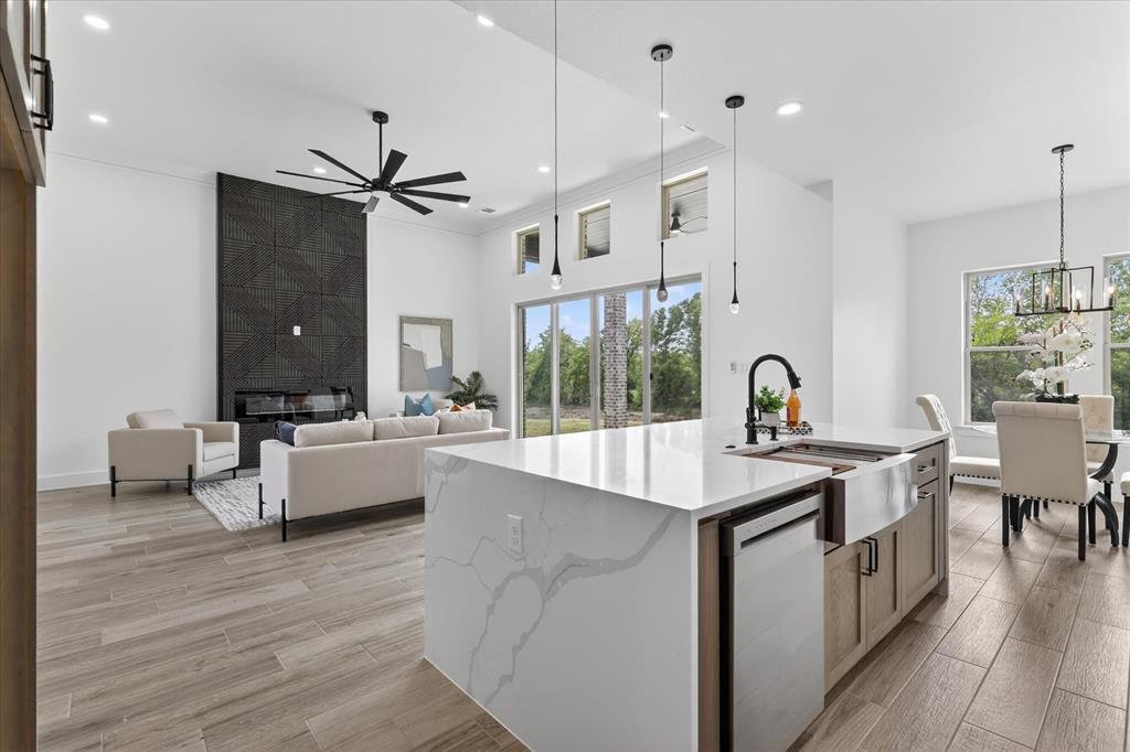 182 Briar Patch Azle, TX 76020 - Photo 12 of 36 Kitchen with light stone counters, an island with sink, light wood finished floors, crown molding, and dishwasher