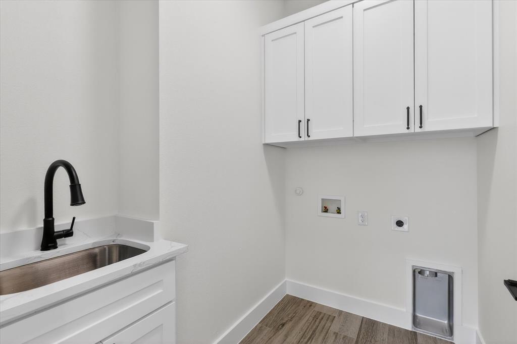 182 Briar Patch Azle, TX 76020 - Photo 23 of 36 Laundry room featuring cabinet space, hookup for a washing machine, electric dryer hookup, and light wood-style flooring