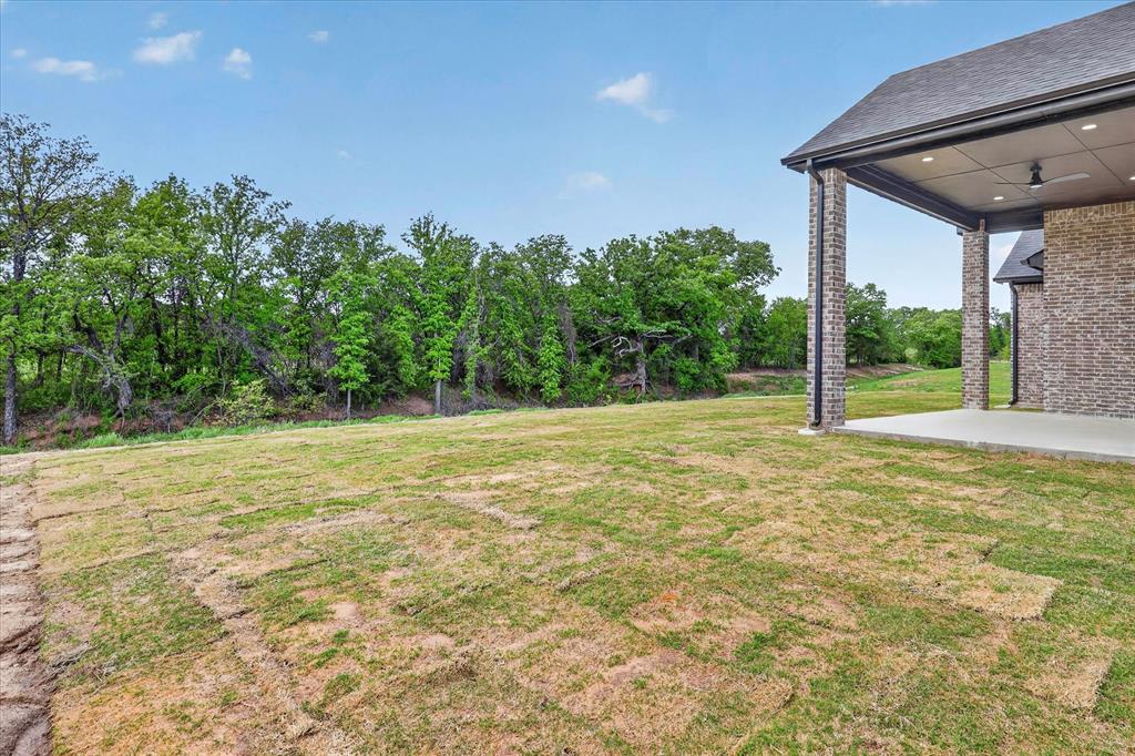 182 Briar Patch Azle, TX 76020 - Photo 34 of 36 View of grassy yard with a patio area, ceiling fan, and view of scattered trees