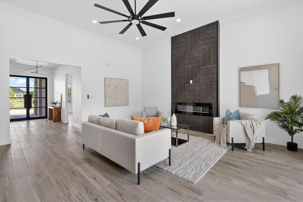 182 Briar Patch Azle, TX 76020 - Photo 4 of 36 Living room featuring ornamental molding, light wood finished floors, a large fireplace, a ceiling fan, and recessed lighting