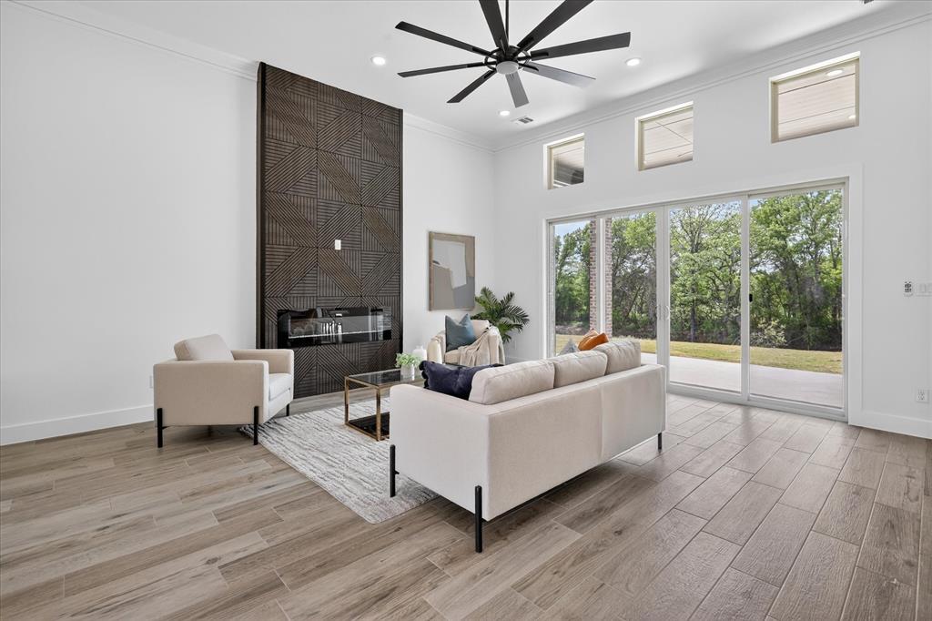182 Briar Patch Azle, TX 76020 - Photo 8 of 36 Living room with a high ceiling, wood finish floors, a fireplace, ceiling fan, and ornamental molding