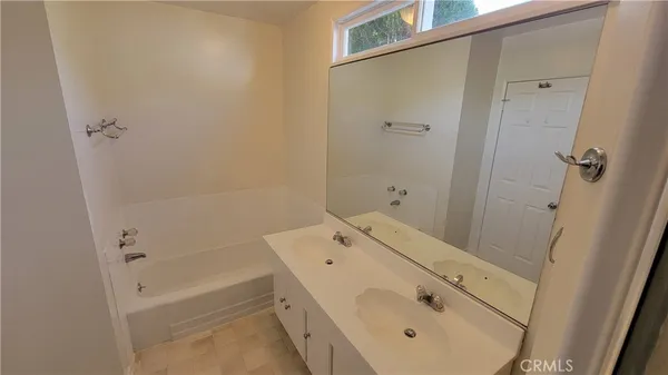 a bathroom with a tub sink a mirror and shower
