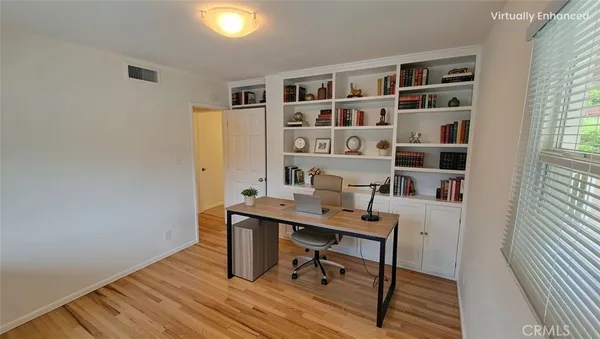 a view of a workspace with furniture and wooden floor