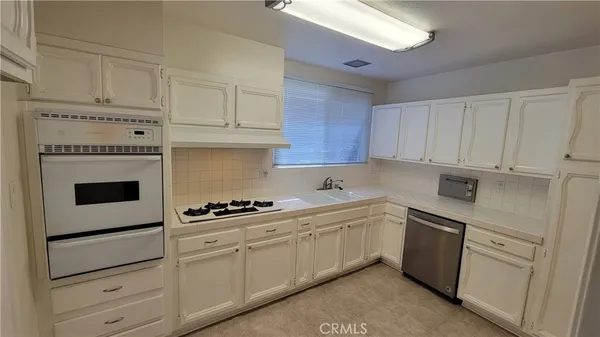 a kitchen with white cabinets and white appliances