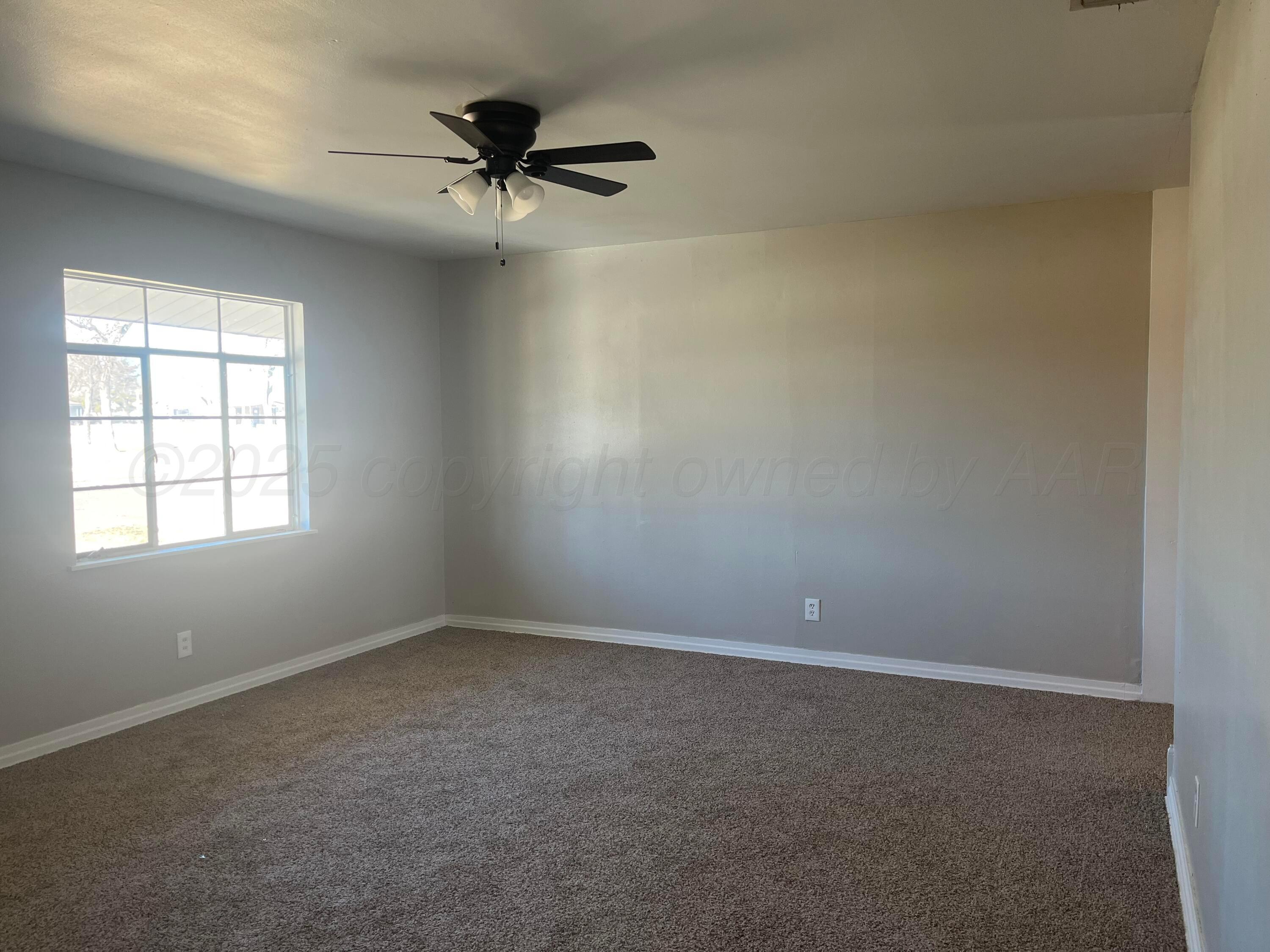 4429 Cline Road Amarillo, TX 79110 - Photo 3 of 29 an empty room with a window and a fan