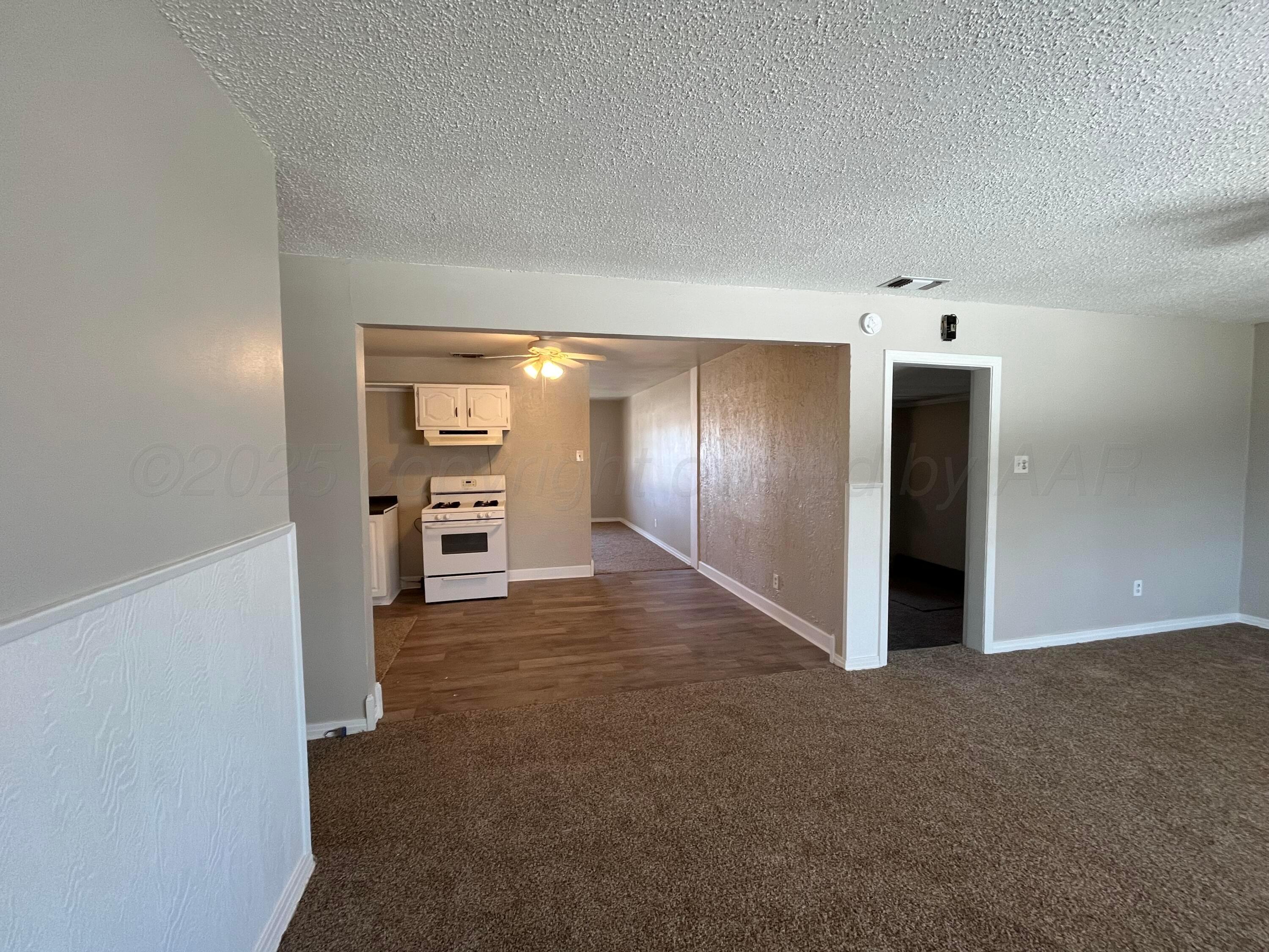 4429 Cline Road Amarillo, TX 79110 - Photo 10 of 29 a view of a room with an empty space and a kitchen