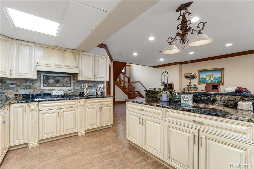 3543 Cedar Brook Drive Rochester, MI 48309 - Photo 47 of 99 Kitchen featuring cream-painted cabinetry, dark granite countertops, and a tile backsplash