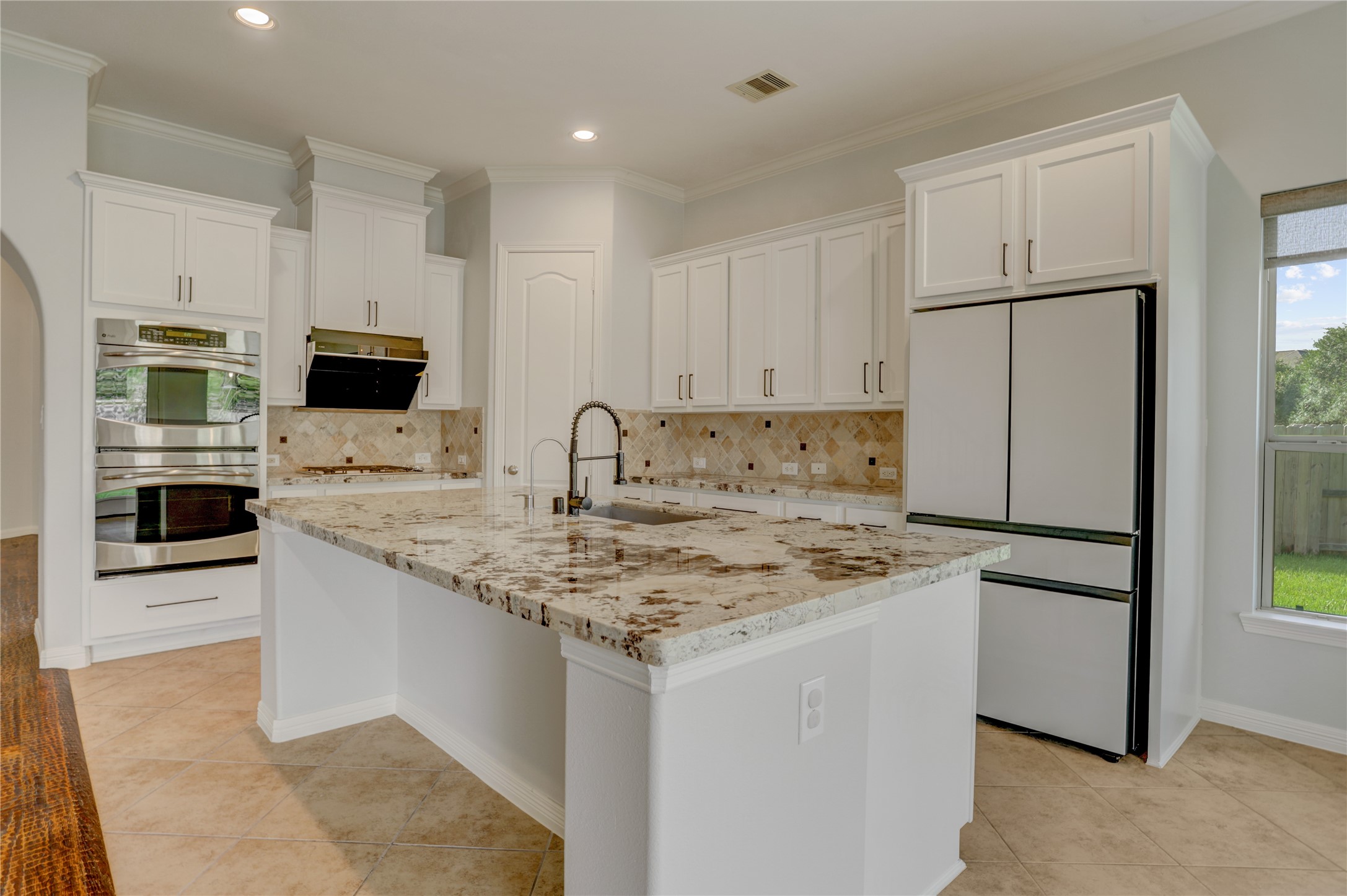 3002 Currant Drive Manvel, TX 77578 - Photo 9 of 43 a kitchen with stainless steel appliances granite countertop a stove a white refrigerator a sink a oven with a dining table and chairs