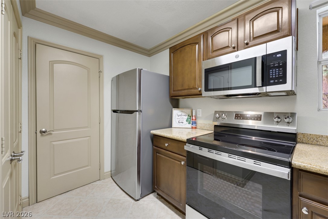 8101 West Flamingo Road, Unit 2136 Las Vegas, NV 89147 - Photo 15 of 32 Rich wood cabinetry and granite countertops frame the stainless steel appliances in this functional kitchen.