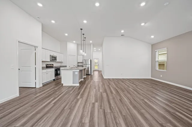 a view of kitchen view wooden floors appliances and cabinets