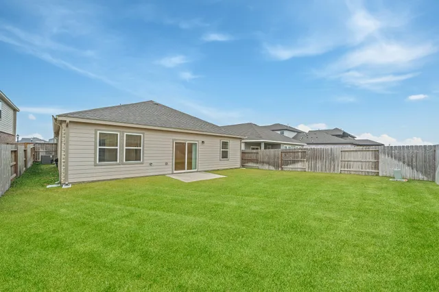a view of a yard in front of a house with a large tree
