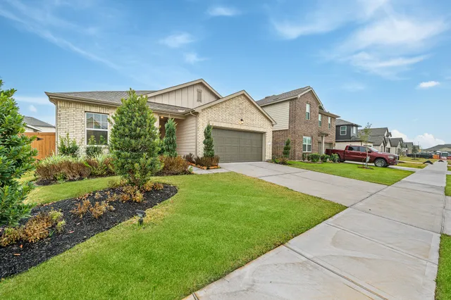 a front view of a house with a garden and plants