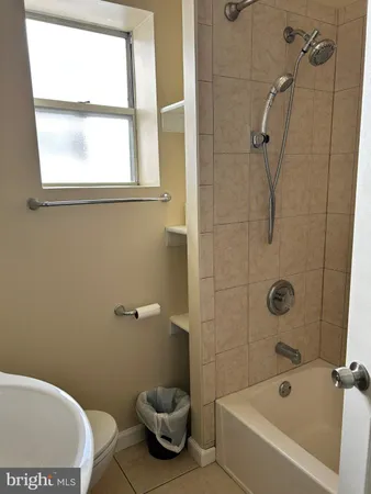 a white bath tub sitting next to a toilet