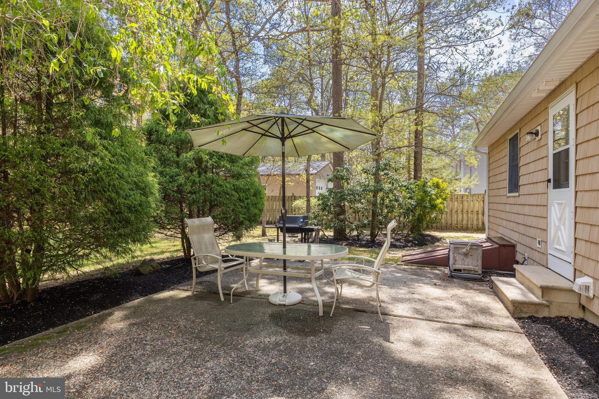 88 Oakshade Road Tabernacle, NJ 08088 - Photo 30 of 34 a view of a patio with table and chairs under an umbrella with large trees