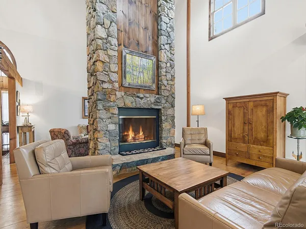 a dining room with furniture a chandelier and wooden floor