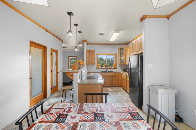 a living room with stainless steel appliances furniture a rug and a dining table