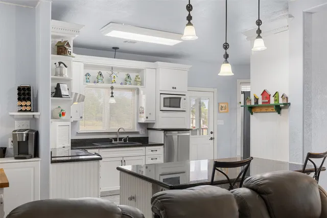 a living room with stainless steel appliances kitchen island granite countertop furniture and a view of kitchen