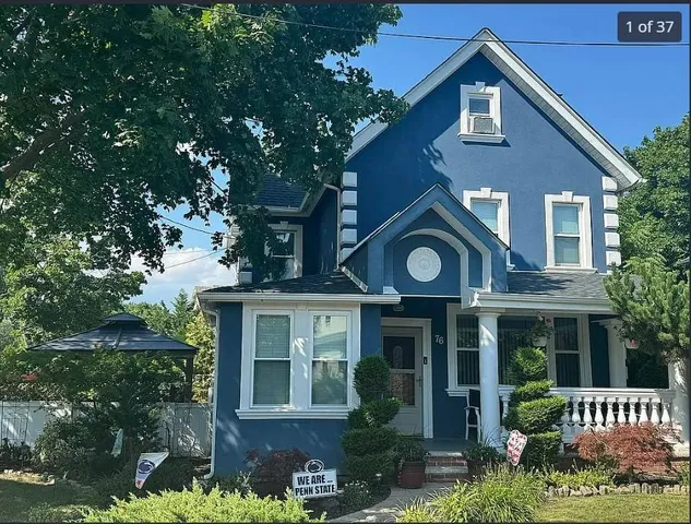 a view of a house with a clock and a tree