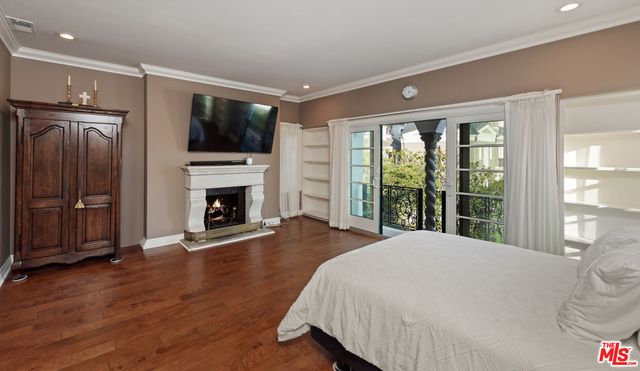 a spacious bedroom with a bed and a flat screen tv