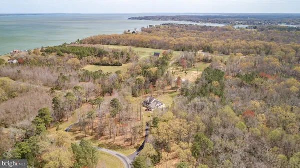 a large kitchen with stainless steel appliances kitchen island granite countertop a refrigerator a sink dishwasher a stove and a dining table with wooden floor