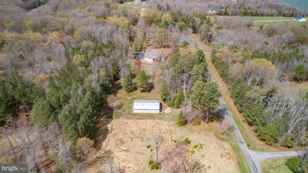 a large kitchen with stainless steel appliances a stove center island a window and living room view