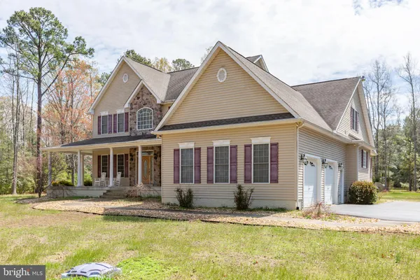 an aerial view of a house with swimming pool and large trees