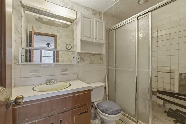 a bathroom with a sink toilet a mirror and shower