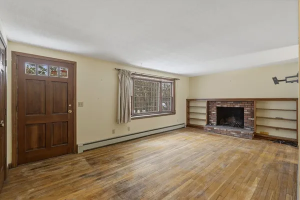 a view of an empty room with a fireplace and a window