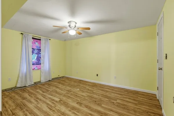 a view of empty room with wooden floor